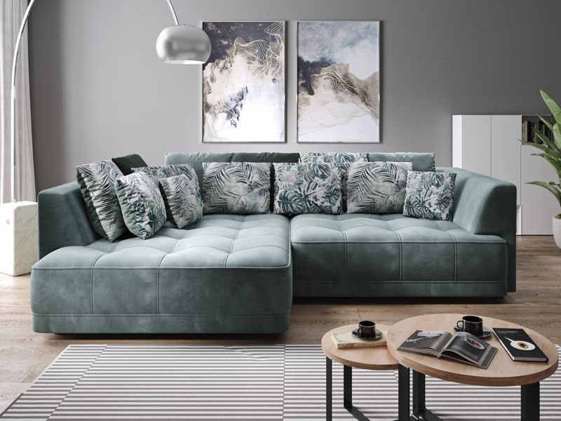 Modern living room with a teal sectional sofa, decorative patterned pillows, abstract wall art, striped rug, and circular wooden coffee tables.