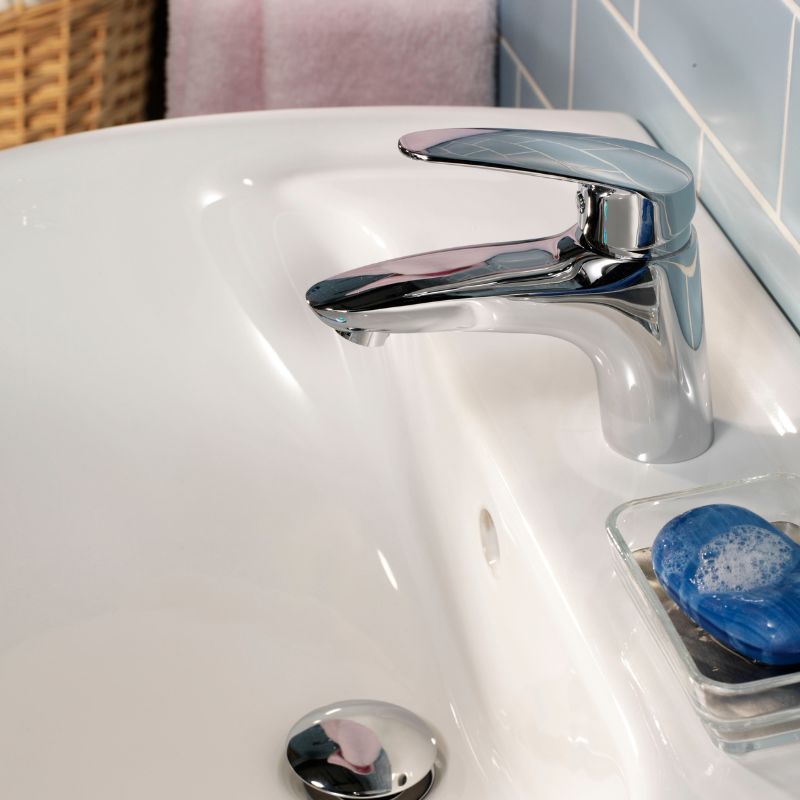 Modern bathroom sink with chrome faucet and a blue soap bar, highlighting potential water damage prevention.