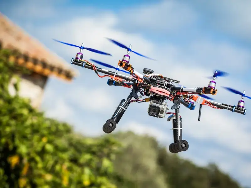 Colorful drone flying outdoors against a blurred background, showcasing drone marketing technology.