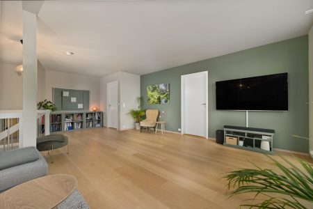 A living room with a couch a chair and a flat screen TV