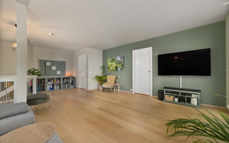 A living room with a couch a chair and a flat screen TV