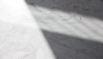 a white marble counter top with a long shadow