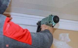 Installation of crown moldings trim on the ceiling of the using gauge finish nailer