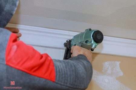 Installation of crown moldings trim on the ceiling of the using gauge finish nailer