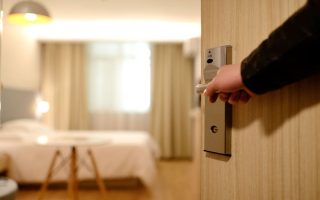 Person Holding on Door Lever Inside Room