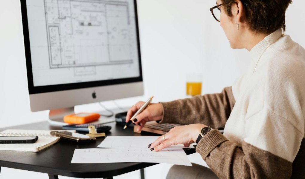 A person working on a computer blueprint to design a floor plan.