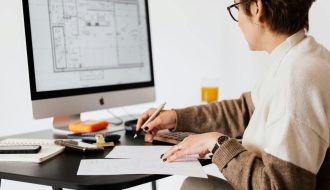A person working on a computer blueprint to design a floor plan.