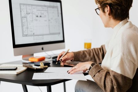 A person working on a computer blueprint to design a floor plan.