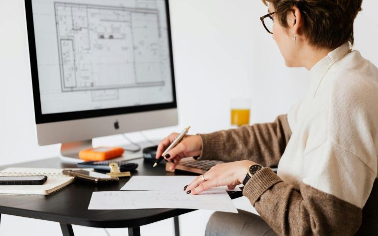 A person working on a computer blueprint to design a floor plan.