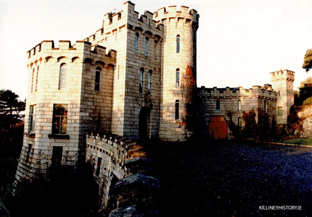Historic view of Victoria Castle in Killiney, built in 1840 with crenellated towers and stone walls.