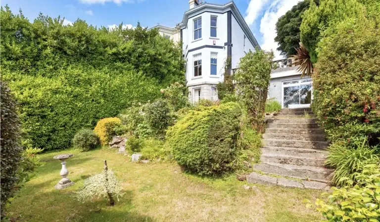 Garden view of Bono’s Dublin villa in Killiney with stone steps leading up to the house.