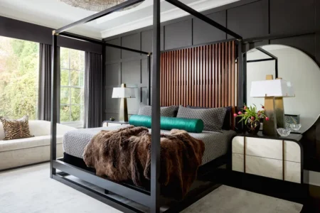 Modern gray and white master bedroom featuring layered linen bedding and a charcoal accent wall